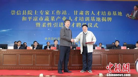 2018年4月，甘肃平凉市委书记郭承录(左)为中国工程院院士、中国农业科学院蔬菜花卉研究所所长、研究员方智远颁发“平凉市柔性引进人才聘书”。(资料图) 艾庆龙 摄